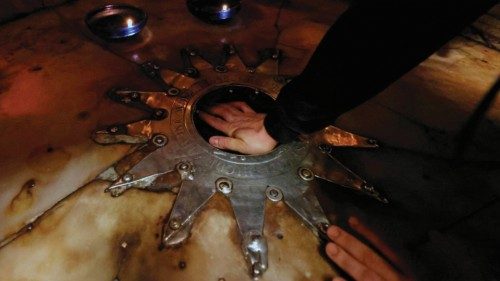 A Christian worshipper touches a 14-pointed silver star, believed to be the exact spot where Jesus ...
