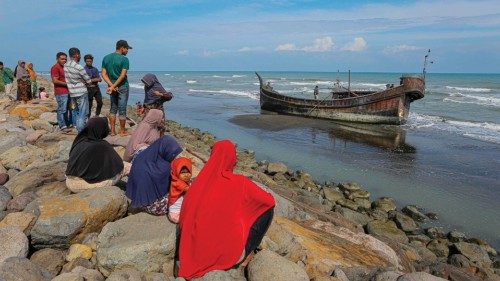 TOPSHOT - Villagers look at a wooden boat used by Rohingya people in Pidie, Aceh province on ...