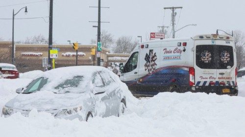 An ambulance passes an abandon car during a winter storm that hit the Buffalo region, in Amherst, ...