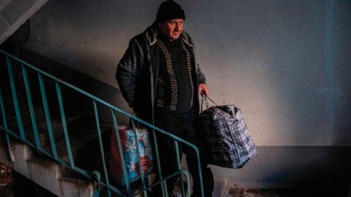 A local resident carries his belongings down the stairs after his apartment was damaged by Russian ... A local resident carries his belongings down the stairs after his apartment was damaged by Russian ...