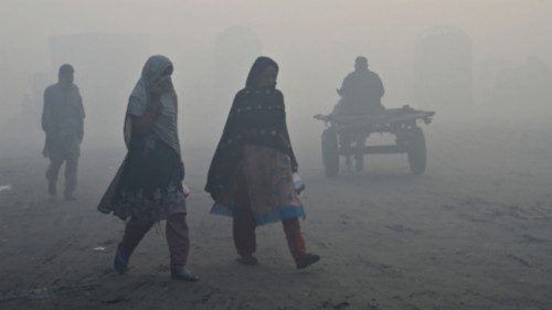 People make their way along a street amid heavy smog conditions in Lahore on December 1, 2022. ...