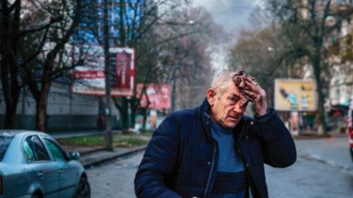 An injured man stands on a street after Russian shelling to Ukrainian city of Kherson on December ...