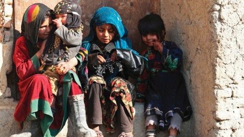 Children sit at the doorstep of a house along the street in Kabul on December 28, 2022. (Photo by ...