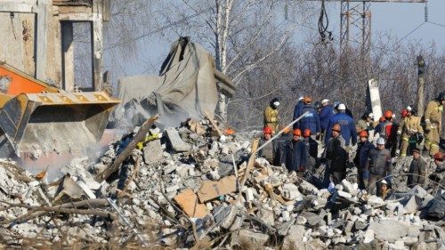 Workers and emergencies' ministry members remove debris of a destroyed building purported to be a ...