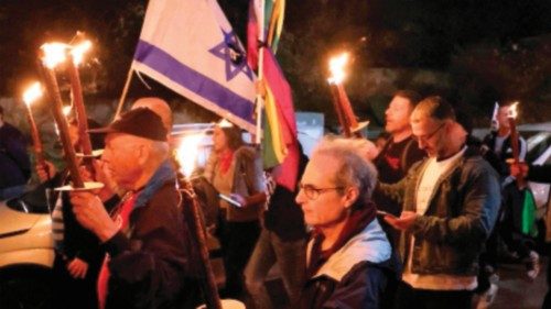 Israeli left wing protesters march with torches during a rally against Israel's new hard-right ...