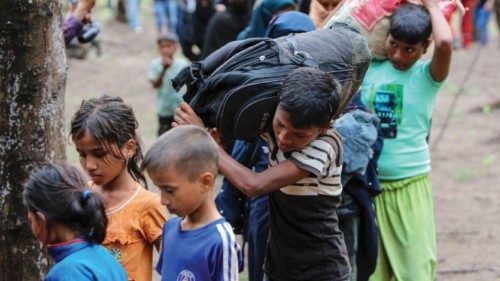 Rohingya refugee children carry their belongings following their arrival at the beach in Gampong ...