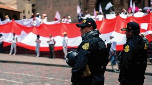Riot police stand guard athe Plaza de Armas in Cusco, Peru on January 15, 2023, as residents carry ...