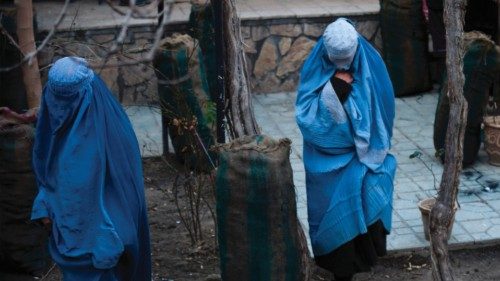 A burqa-clad women collect charcoal donated by a volunteer team in Kabul on January 13, 2023. (Photo ...