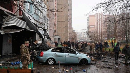 Military and onlookers stand at the site where a helicopter crashed near a kindergarten outside the ...