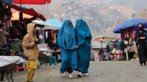 TOPSHOT - Afghan burqa-clad women walk past a market at Fayzabad district, in Badakhshan province on ...