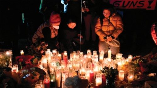 TOPSHOT - People pay tribute to the victims of the mass shooting at a candlelight vigil in front of ...