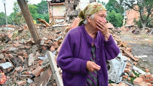 TOPSHOT - A local resident, Raisa Kuval, 82, reacts next to a damaged building partially destroyed ... TOPSHOT - A local resident, Raisa Kuval, 82, reacts next to a damaged building partially destroyed ...