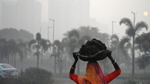 TOPSHOT - A woman carries cow-dung on her head before drying it to use as fuel for cooking amid ...