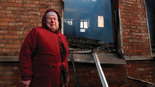 Olga Tomah, 70, stands in front of a residential building where her flat burns after Russian ...