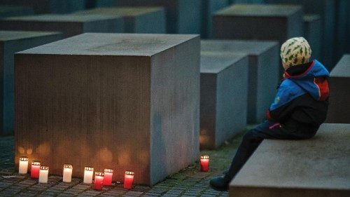 epa10431497 Mourning candles are placed around steles as a young boy sits next to the scene during a ... epa10431497 Mourning candles are placed around steles as a young boy sits next to the scene during a ...