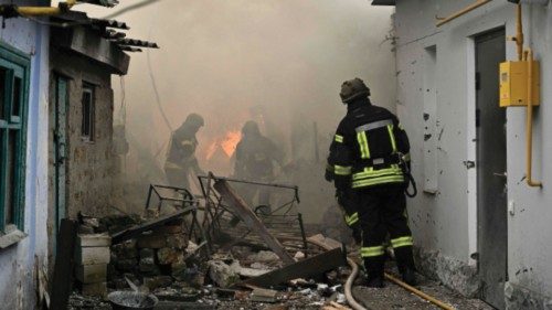 Ukrainian firefighters work to extinguish a fire in a house following Russian shelling in the city ...