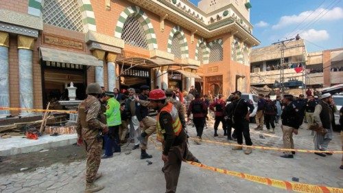 Security personnel cordon-off the site of a mosque blast inside the police headquarters in Peshawar ...