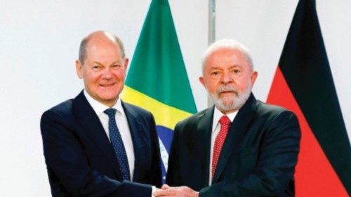 Brazilian President Luiz Inacio Lula da Silva (R) shakes hands with German Chancellor Olaf Scholz ...