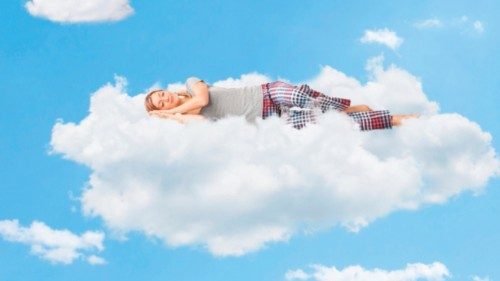 Tranquil scene of a young woman dreaming and sleeping on a cloud up in the sky