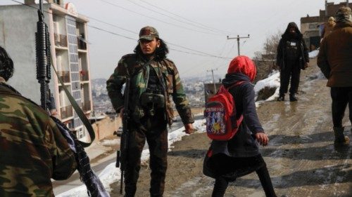 An Afghan girl walks among Taliban soldiers on a street in Kabul, Afghanistan, January 31, 2023. ...