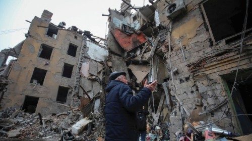 A local resident stands near a residential building destroyed by a Russian missile strike, amid ...