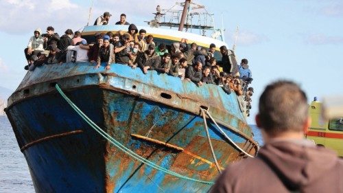 FILE PHOTO: Migrants stand onboard a fishing boat at the port of Paleochora, following a rescue ...