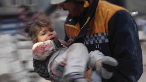 A rescuer carries an injured child away from the rubble of a building following an earthquake in ...