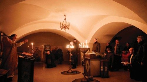 Orthodox Christians attend the Sunday prayer at the basement of the Church of All Saints as sounds ...