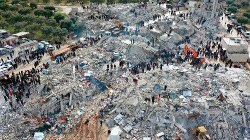 TOPSHOT - This aerial view shows residents searching for victims and survivors amidst the rubble of ...