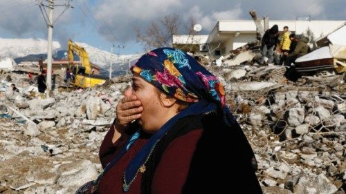 A woman gestures while sitting amidst rubble and damages following an earthquake in Gaziantep, ...