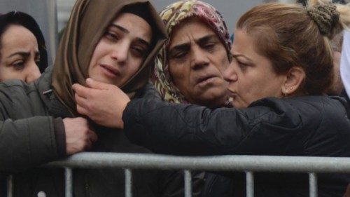 Women react as they watch rescue personnel search for victims and survivors through the rubble of ...