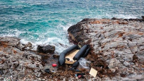 TOPSHOT - A rubber boat, believed to be used by migrants, lies destroyed on the rocky shoreline, in ...