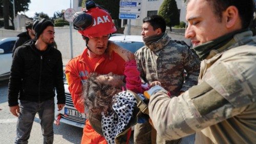 Rescuers carry an alive girl after she was pulled from the rubble in the aftermath of a deadly ...