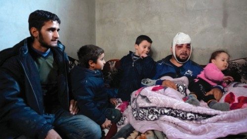 A Syrian man who was injured in a deadly earthquake sits among family members in a make-shift ...