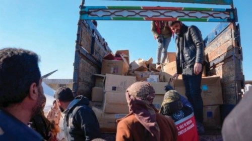 CORRECTION / Syrians receive aid at a make-shift shelter near the rebel-held town of Jinidayris on ...