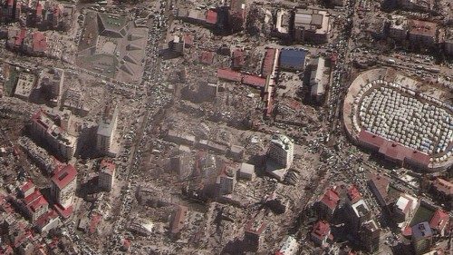 A satellite image shows destroyed buildings and emergency shelters in a stadium after an earthquake ...