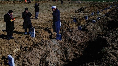 People mourn their lost relatives at a mass grave area in Hatay, on February 10, 2023, four days ...