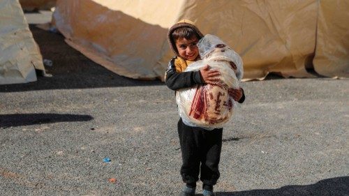 A Syrian child carries bread at a make-shift shelter for people who were left homeless, near the ...