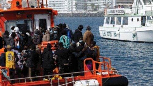 Tourists from a pleasure boat observe a group of migrants rescued by Spanish coast guard vessel, in ...