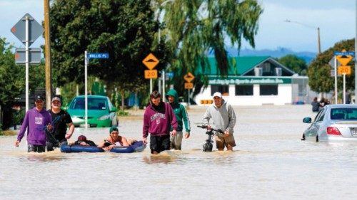 A photo taken on February 15, 2023 shows people wading through flood waters in the city of Napier, ...
