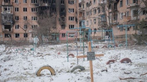 A view shows a grave of a local resident near buildings damaged by a Russian military strike, as ...