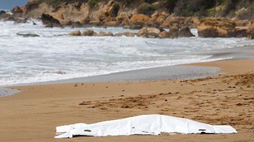 A covered body is seen on the beach in the aftermath of a deadly migrant shipwreck, in Le Castella, ...