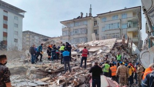 Rescuers carry on search operations among the rubble of collapsed buildings in the Yesilyurt ...