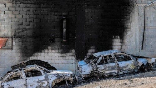 This picture taken on February 27, 2023 shows a view of torched cars and a building in the town of ...