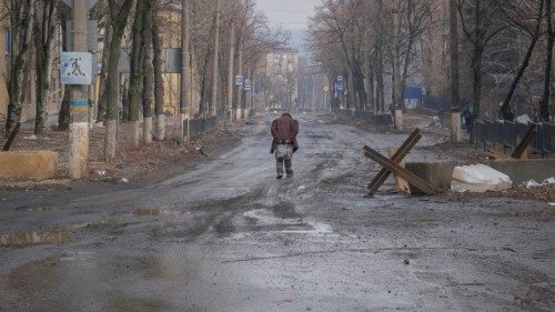 A local resident walks along an empty street, as Russia's attack on Ukraine continues, in the ...
