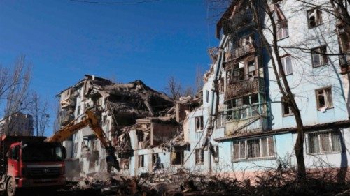Ukrainian rescuers work with an excavator on a five-storey residential building destroyed after a ...