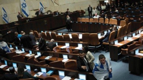 An Israeli lawmaker is pursued by security as he drapes himself in the national flag in protest at ...