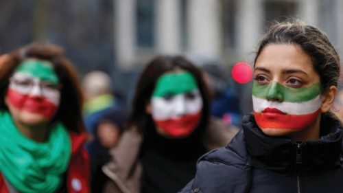 Women, with their faces painted in the colors of Iran's flag, take part in a protest by Iranian ...
