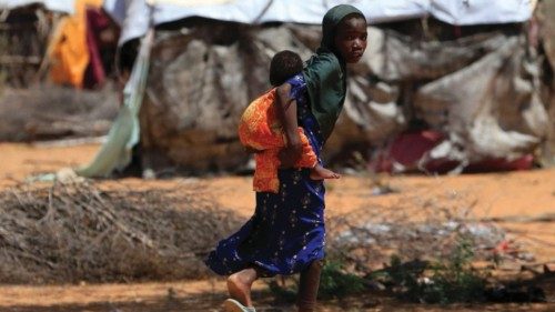 A Somali refugee girl carries her sibling as they walk in their new arrivals area of the Hagadera ...