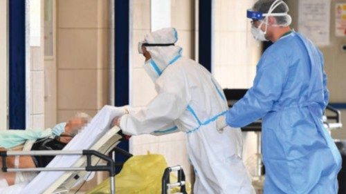 Health workers wearing protective suits transfer a patient infected with COVID-19 into the San ...